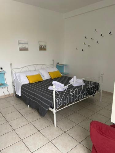 - une chambre avec un lit doté d'oreillers jaunes dans l'établissement Holiday Gels appartamento vacanze Ostia, à Lido di Ostia