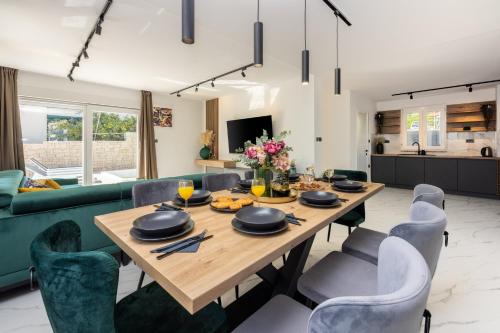 uma sala de jantar e sala de estar com mesa e cadeiras em Villa Ketty em Baska