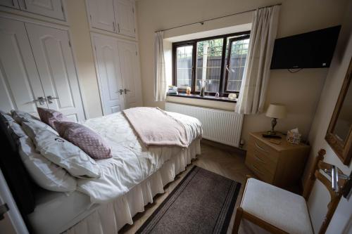 a small bedroom with a bed and a window at The New Larches in Bewdley