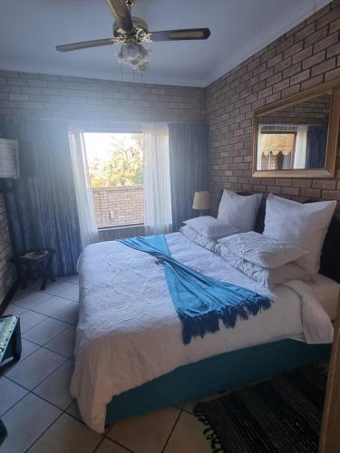 a bedroom with a large bed with a ceiling fan at Villa Majestic for Exclusive Accommodation in Port Alfred