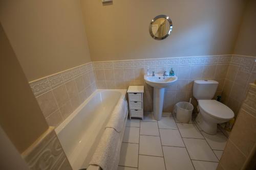 een badkamer met een bad, een toilet en een wastafel bij The New Larches in Bewdley