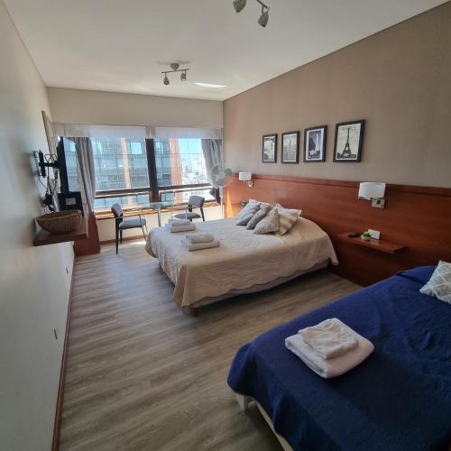 a hotel room with two beds and a window at Dg Apart Obelisco in Buenos Aires