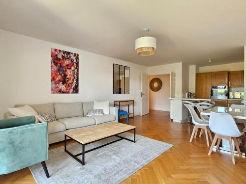 un salon avec un canapé et une table dans l'établissement Grand 3 pièces, 2 jardins, Parking sous sol., à Deauville