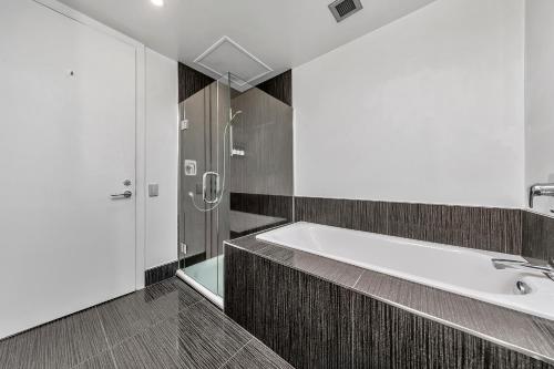 a bathroom with a large tub and a shower at Stunning Auckland Harbour Views in Auckland