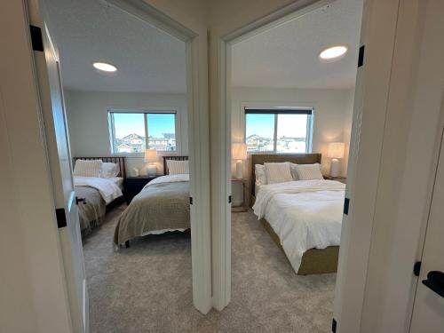 a bedroom with two beds and two windows at The Evergreen House in Red Deer