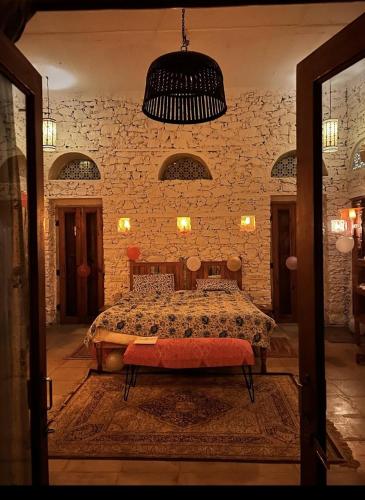 a bedroom with a bed in a brick wall at the secret garden in Pushkar