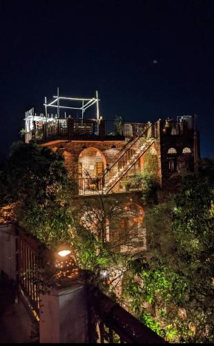 a stone building with a staircase at night at the secret garden in Pushkar