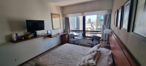 a bedroom with a large window with a view of a city at Dg Apart Obelisco in Buenos Aires
