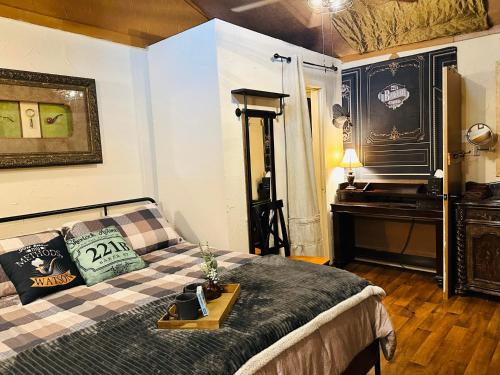 um quarto com uma cama com uma mesa e um piano em Acorn Hideaways Canton Secluded Sherlock Holmes Suite King Bed em Canton