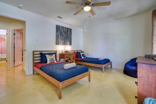 a bedroom with two beds and a ceiling fan at San Antonio Townhome 3 Mi to Lackland AFB! in San Antonio