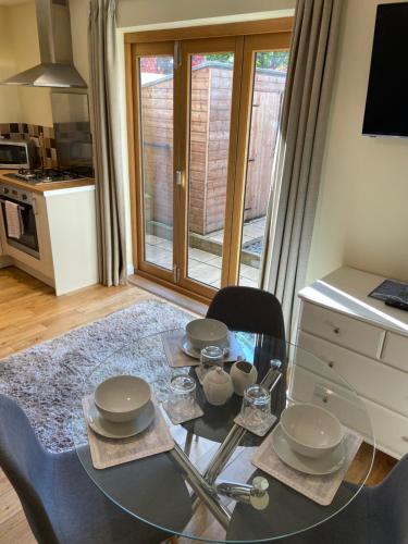 a dining room with a glass table and chairs at Ashton Gate Mews in Bristol