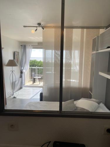 um quarto com uma janela com uma cama e uma varanda em Appartement Studio 35 m2 face à l'Ocean em Saint-Brévin-les-Pins