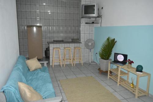 sala de estar con sofá azul y cocina en Villagio Vistamar Ilha Comprida, en Ilha Comprida