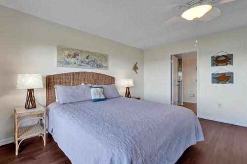 a bedroom with a large bed and two lamps at Direct Oceanfront Condo Amazing Views Cocoa Beach in Cocoa Beach