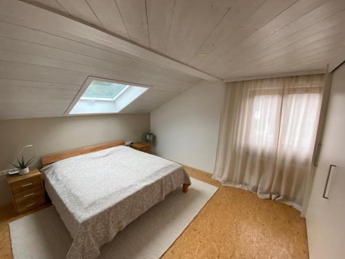 ein Schlafzimmer mit einem Bett und einem Dachfenster in der Unterkunft RM Apartment for Moments in Dornbirn