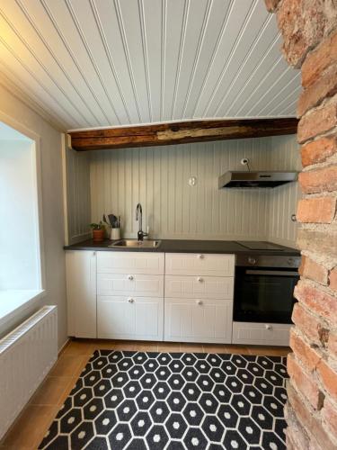 uma cozinha com um lavatório e uma bancada em Historical idyll from the 17th century em Strängnäs