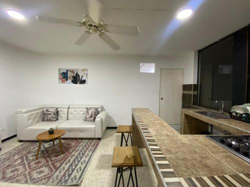 卡利的住宿－APARTAMENTO ESTADIO，客厅配有白色的沙发和桌子