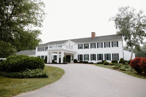 a white house with a driveway in front of it at The Litchfield Inn in Litchfield