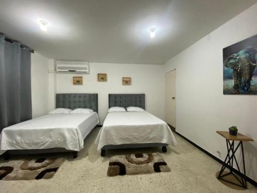 卡利的住宿－APARTAMENTO ESTADIO，一间卧室配有两张床和一张桌子