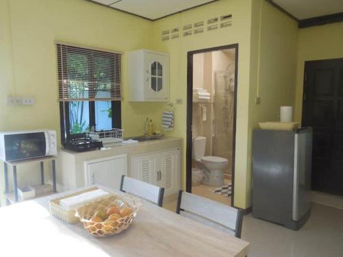 a kitchen with a table with a bowl of fruit on it at Guest House, shared pool, private bathroom and kitchen in Phuket Town