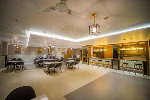 a restaurant with tables and chairs and a bar at Kyriad Prestige Ilkal in Ilkal