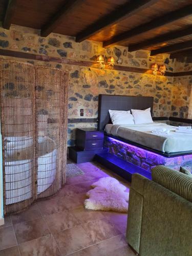 Dormitorio con cama con iluminación púrpura en Suites Mouses, en Palaios Agios Athanasios
