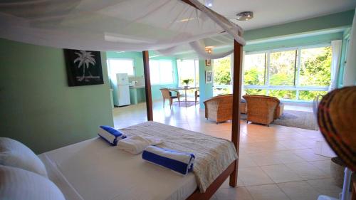 een slaapkamer met een bed en een woonkamer bij The Tree House Bella Seaview Diani Beach Kenya in Diani Beach