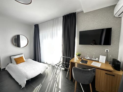 a hotel room with a bed and a desk and a tv at La Vista Luxury Villa in Ohrid