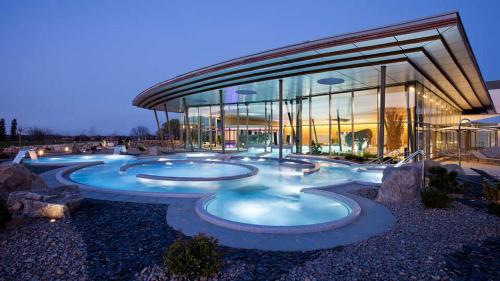 een gebouw met drie zwembaden ervoor bij Gîte Petite Palette in Ribeauvillé