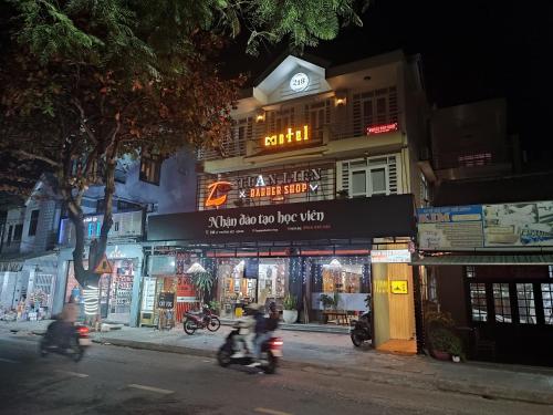 twee mensen die 's nachts op een motor door een straat rijden bij Nhà nghỉ 218 in Hội An