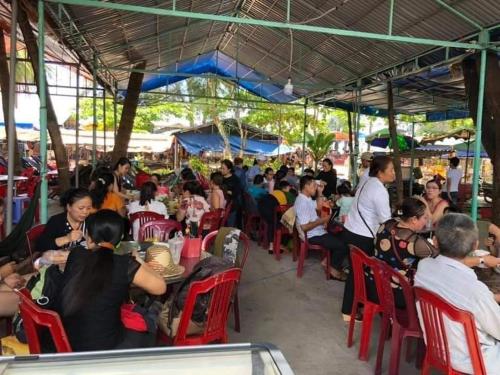 un gran grupo de personas sentadas en sillas en un restaurante en Nhà Nghỉ Việt Thắng en Bàu Dòi