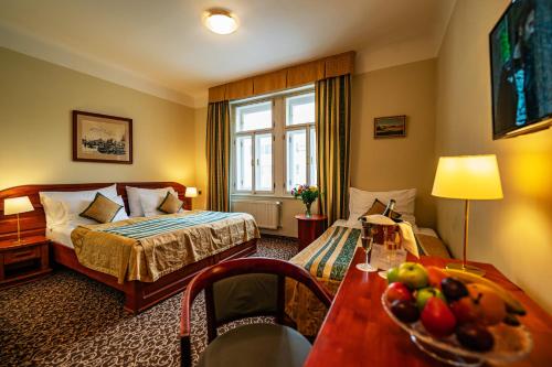 een hotelkamer met een bed en een tafel met fruit erop bij Hotel U Divadla in Praag