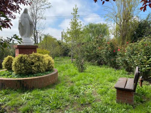 a statue and a bench in a garden at Casa en entorno natural in Curicó