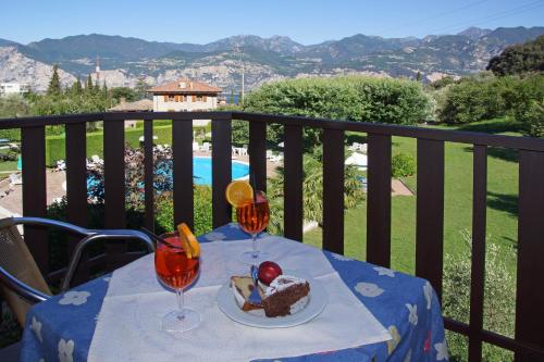 a table with a plate of food and two wine glasses at Park Hotel Val Di Monte ***S in Malcesine