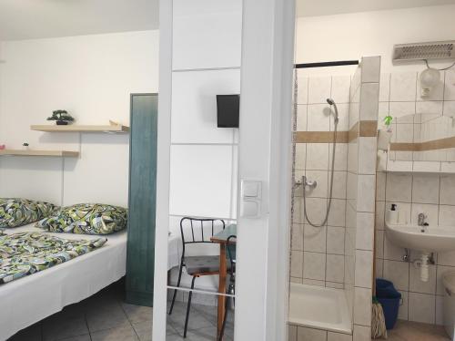 ein Bad mit einem Bett, einer Dusche und einem Waschbecken in der Unterkunft Holdfeny Vendeghaz in Abádszalók
