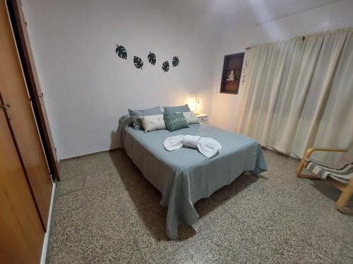 een slaapkamer met een bed met twee handdoeken erop bij MAILY Guest House in Alta Gracia