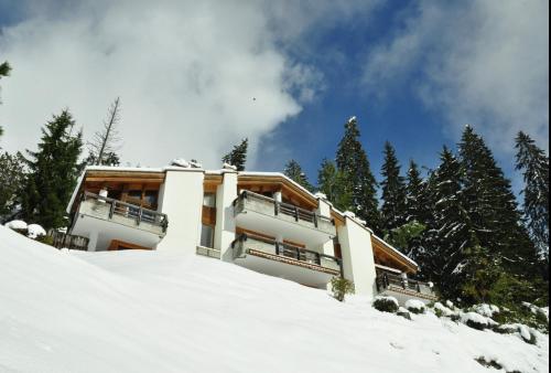 a building on top of a snow covered slope at Crap da Flem - 3.5 Zimmer Ferienwohnung am Sonnenhang von Flims in Flims