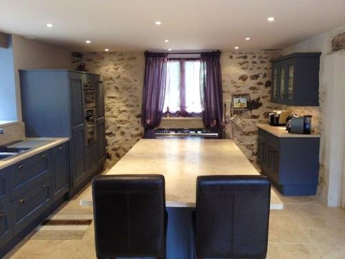 a kitchen with blue cabinets and a large kitchen island at Maison spacieuse avec jacuzzi à Saint-Georges-sur-Baulche in Saint-Georges-sur-Baulche