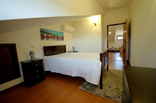 1 dormitorio con 1 cama blanca grande y espejo en 4 bedrooms house with city view balcony and wifi at Santa Maria da Feira, en Aveiro