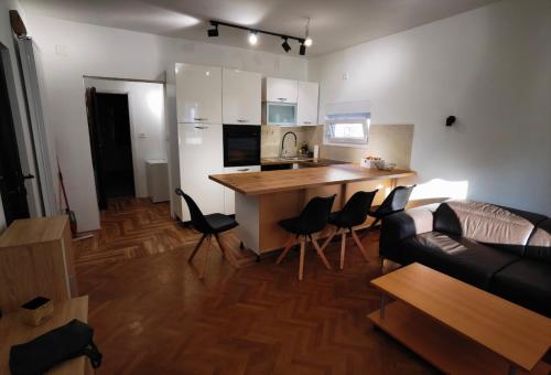 ein Wohnzimmer mit einem Sofa und eine Küche mit einer Theke in der Unterkunft Apartments Dijana in Rab