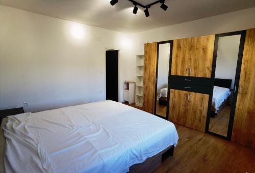 ein Schlafzimmer mit einem großen weißen Bett und einem Spiegel in der Unterkunft Apartments Dijana in Rab