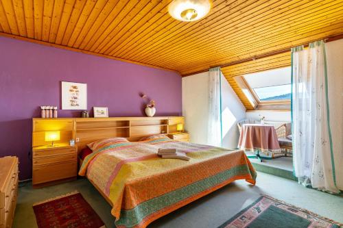 a bedroom with a bed and a purple wall at Ferienwohnung Anne und Peter Bosch in Alpirsbach