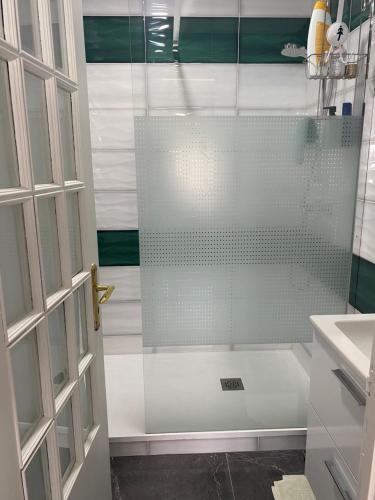um chuveiro com uma porta de vidro na casa de banho em Casa Alves em Palmela