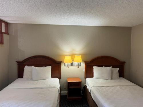 two beds in a hotel room with two lamps at Homegate Studio and Suites San Antonio in San Antonio