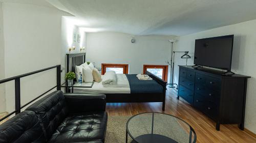 een slaapkamer met een bed en een tv en een bank bij Cosy Corner - Entire Apartment near Oktogon in Boedapest
