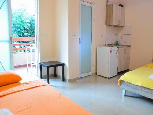 a room with two beds and a kitchen with a refrigerator at Vila Stefani in Star Dojran