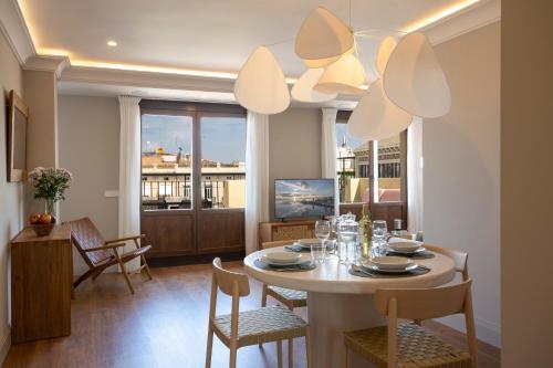 uma sala de jantar com uma mesa e cadeiras e uma janela em SingularStays Ático Reina Catalina em Valência