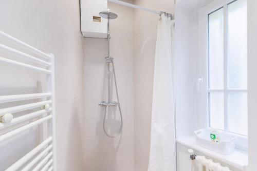 La salle de bains blanche est pourvue d'une douche avec rideau de douche. dans l'établissement Le Grand Patural, à Ban-Saint-Martin