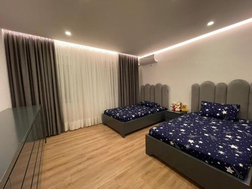 een slaapkamer met 2 bedden en een raam met gordijnen bij Royal Seaview Apartment in Durrës