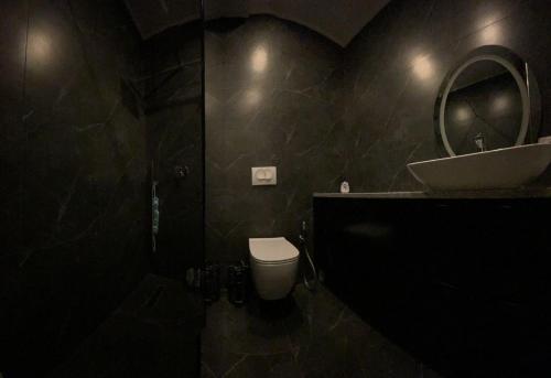 a bathroom with a toilet and a sink and a mirror at Royal Seaview Apartment in Durrës